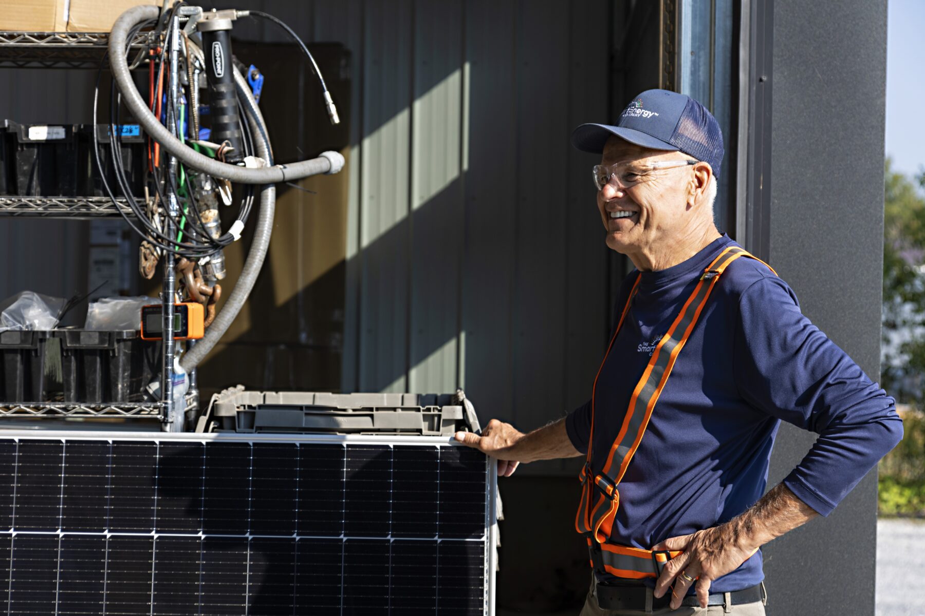 Smart Energy Company team member standing beside a solar panel.