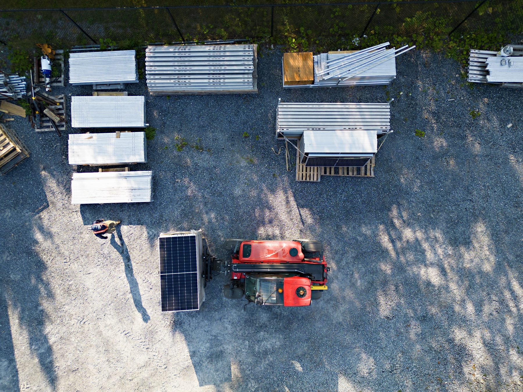 Ground-mounted solar panels and installation equipment viewed from above.
